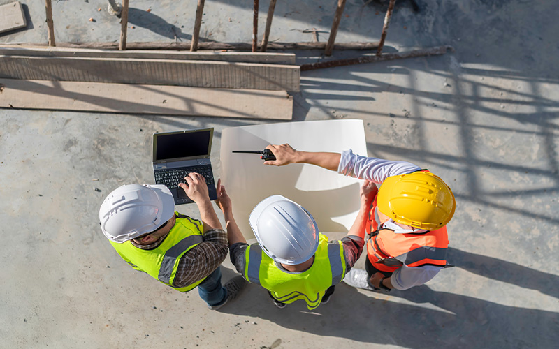 Engineers and project manager collaborating at a construction site.