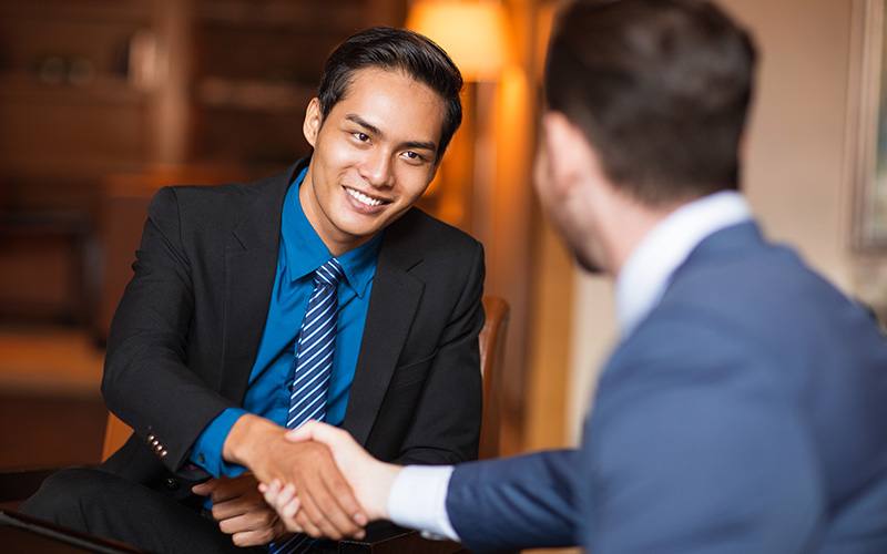 HR professional shaking hands with a candidate.