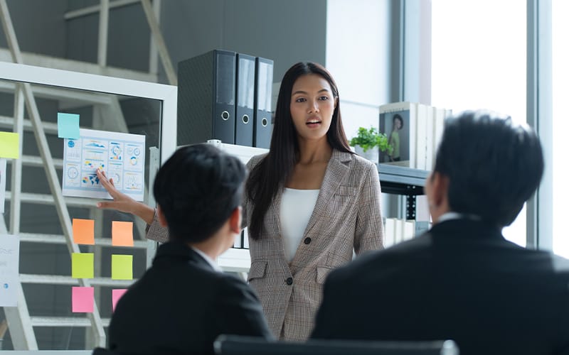 A business professional giving a presentation to colleagues.