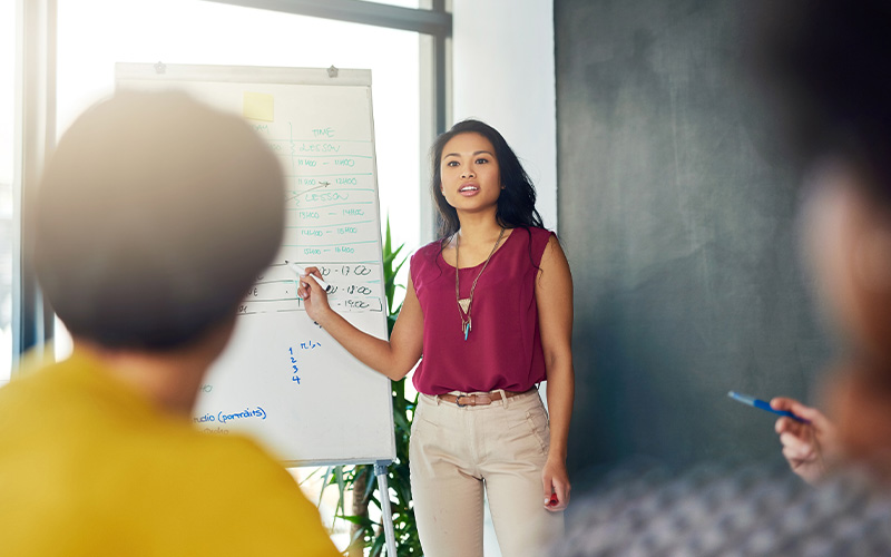 A confident woman presenting a project to her team.