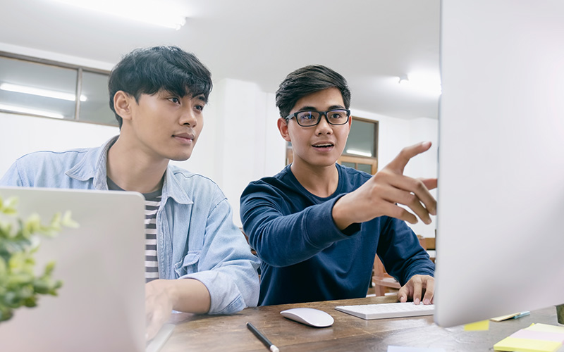 Two digital forensics students collaborating on an investigation