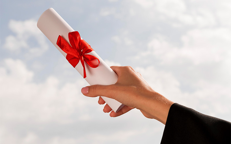 A hand holding a degree cert