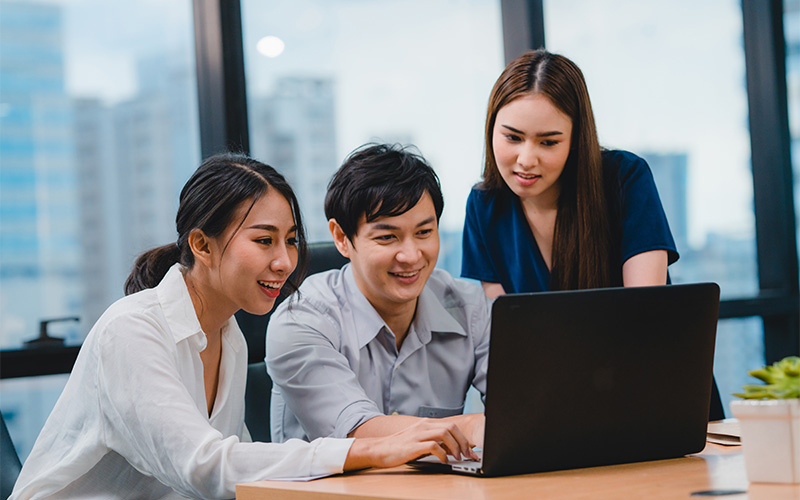 Team collaborating on a laptop in a startup.