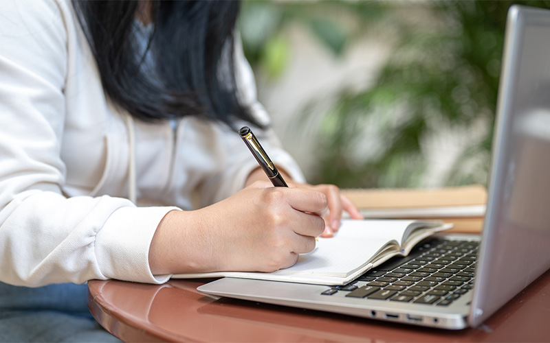 A woman working on an assignment using a laptop