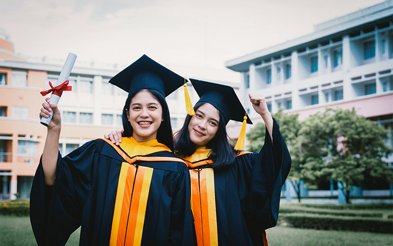 Two students celebrating at a graduation ceremony